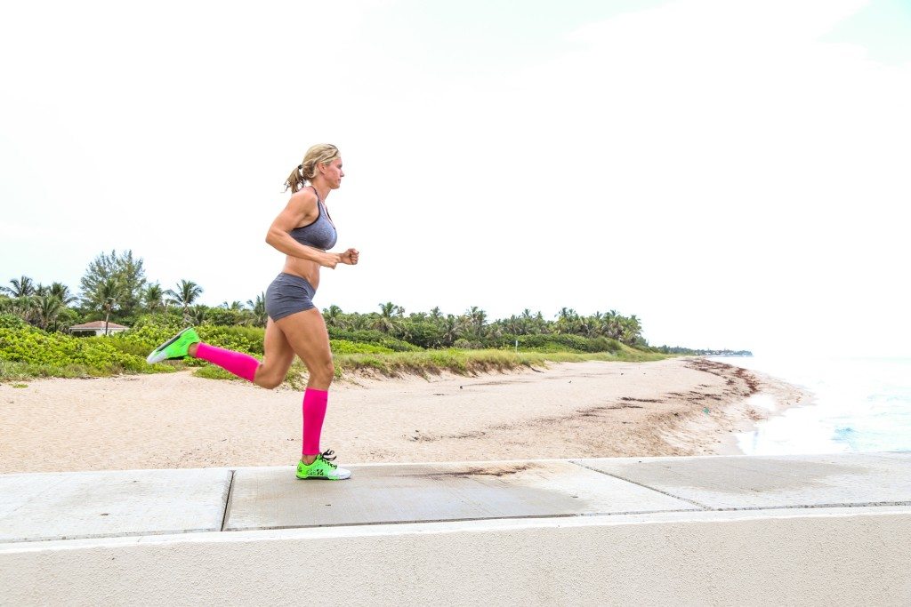 woman running in pink leg sleeves