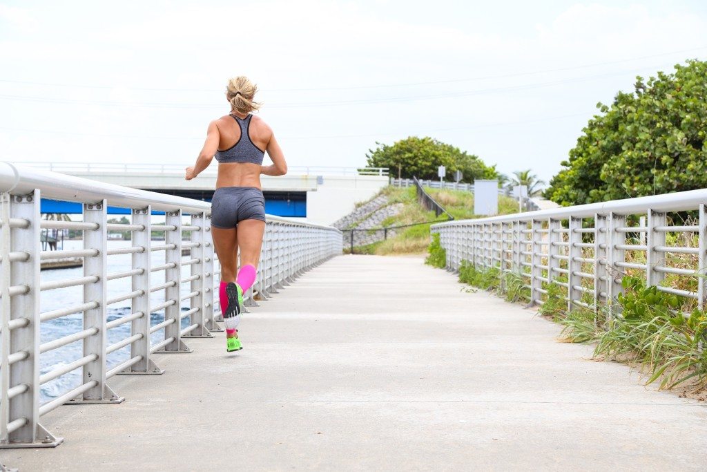 female runner with pink compression calf sleeves
